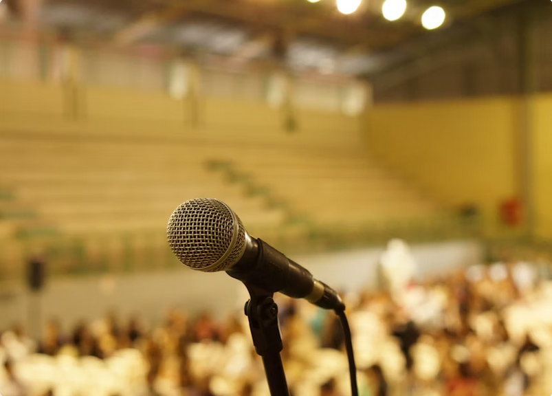 annual conference about Microphone in focus in a stadium.